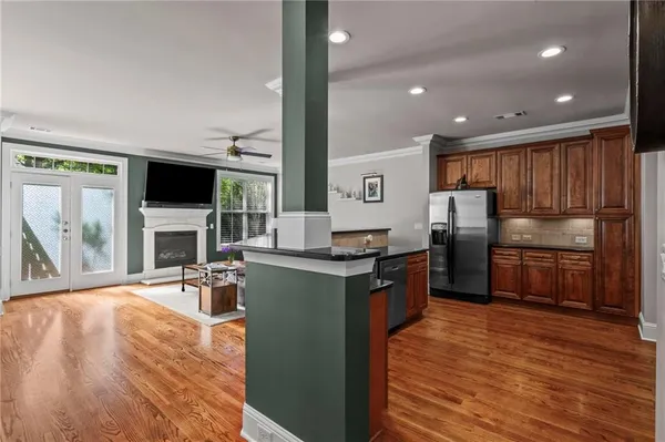 a kitchen with stainless steel appliances wooden floors and wooden cabinets