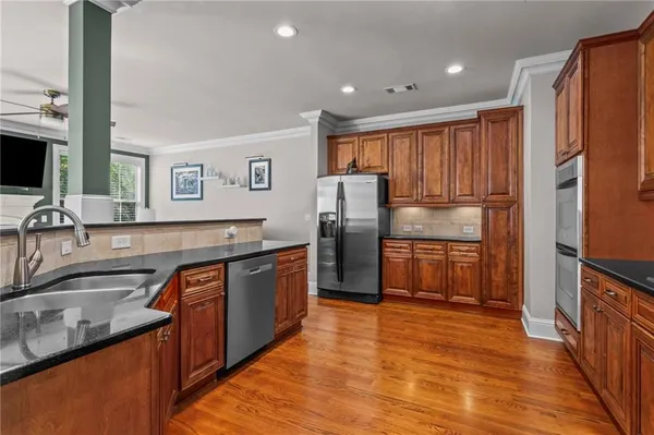 a kitchen with stainless steel appliances granite countertop a refrigerator and a sink