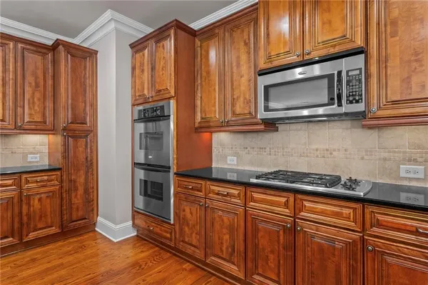 a kitchen with granite countertop wooden cabinets and stainless steel appliances