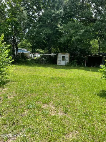 a view of a garden with a building in the background