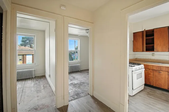 an empty room with a window and a ceiling fan