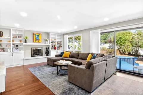 a living room with fireplace furniture and a large window