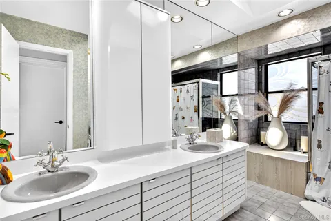 a bathroom with double vanity sink and a mirror