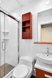 a bathroom with a sink a toilet and shower