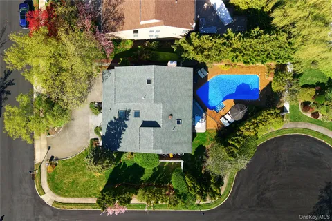 an aerial view of a house with a yard and large trees