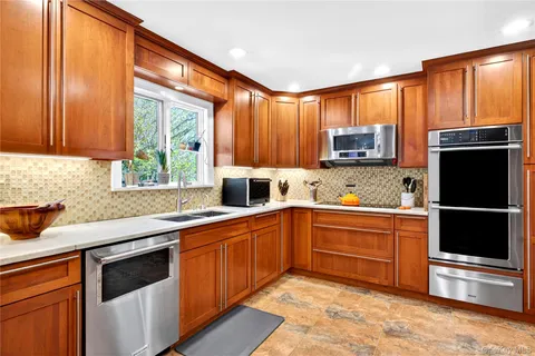 a kitchen with stainless steel appliances granite countertop a stove a sink dishwasher and a microwave oven with cabinets