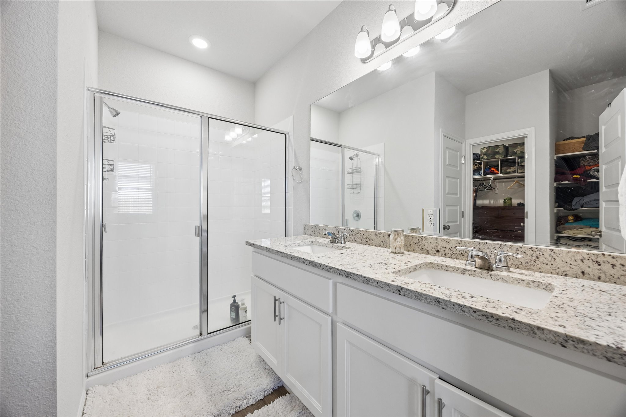 8300 Augeron Drive Austin, TX 78747 - Photo 10 of 16 Bathroom featuring double vanity, a shower stall, and a spacious closet