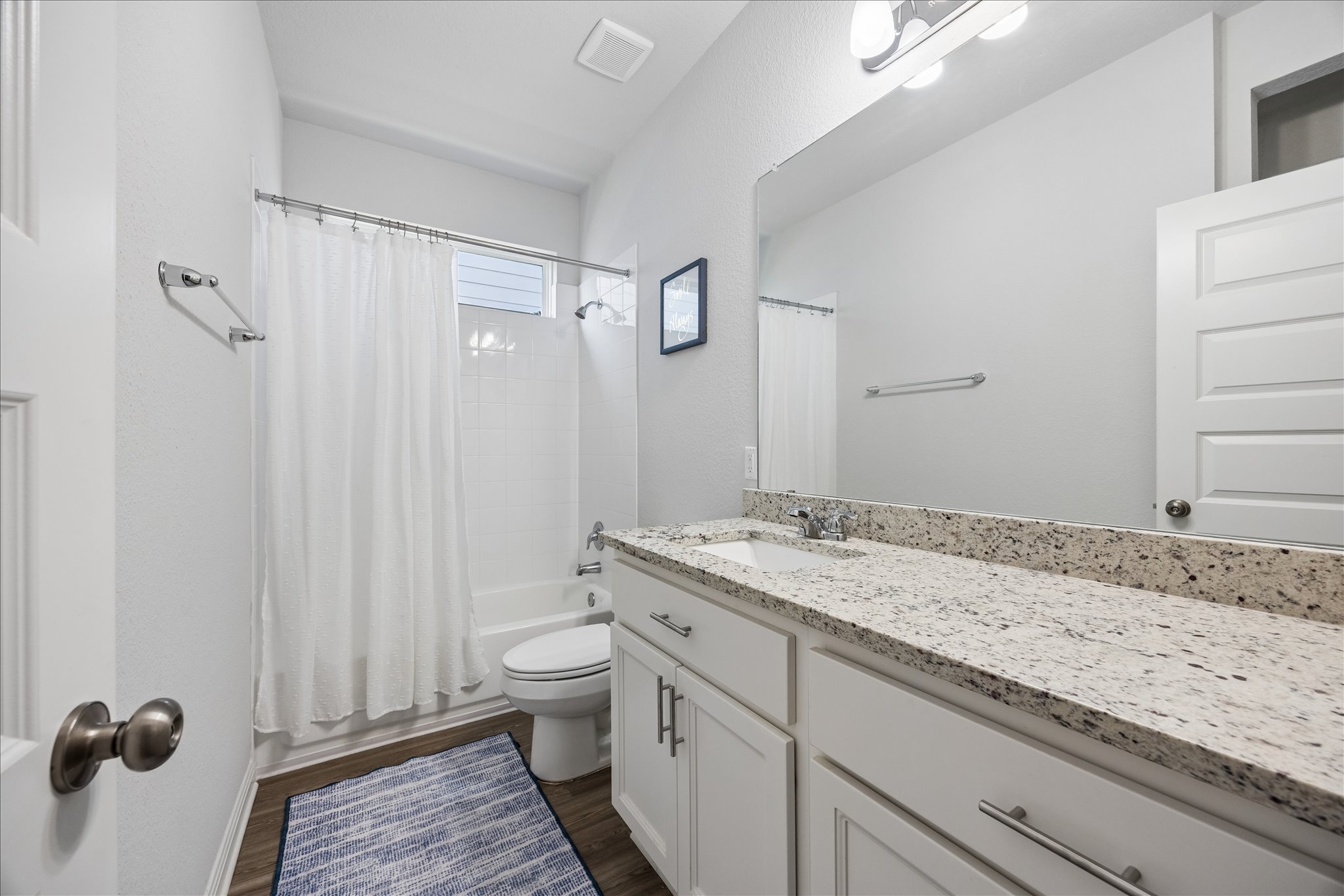 8300 Augeron Drive Austin, TX 78747 - Photo 12 of 16 Full bath with vanity, shower / bath combo with shower curtain, and dark wood-type flooring