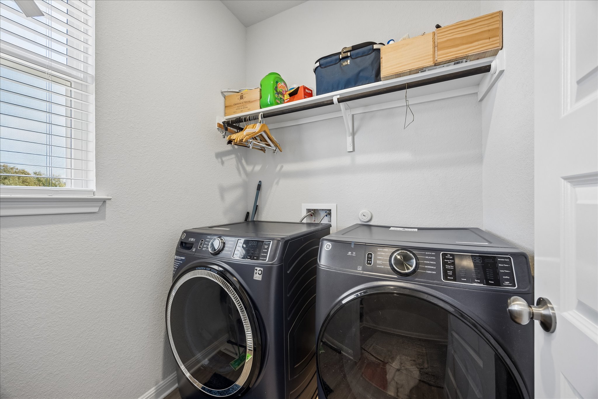 8300 Augeron Drive Austin, TX 78747 - Photo 13 of 16 Laundry area with a textured wall and washing machine and clothes dryer