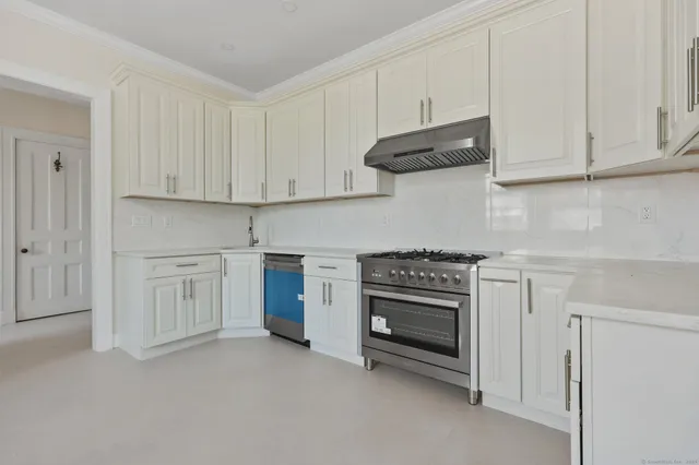 a kitchen with white cabinets and a stove