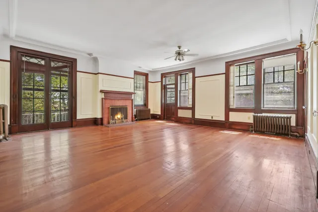 wooden floor fireplace and windows in an empty room
