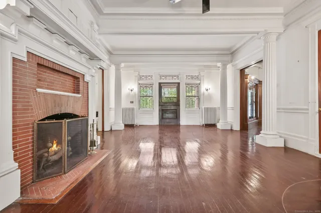 a view of a hallway with wooden floor fireplace and windows