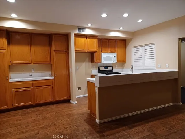 a kitchen with stainless steel appliances granite countertop a refrigerator and a stove top oven