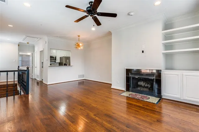 a view of a kitchen and an empty room with wooden floor