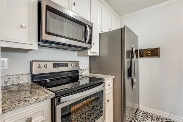 a kitchen with stainless steel appliances granite countertop a refrigerator stove and microwave