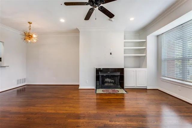 a view of empty room with wooden floor and fireplace