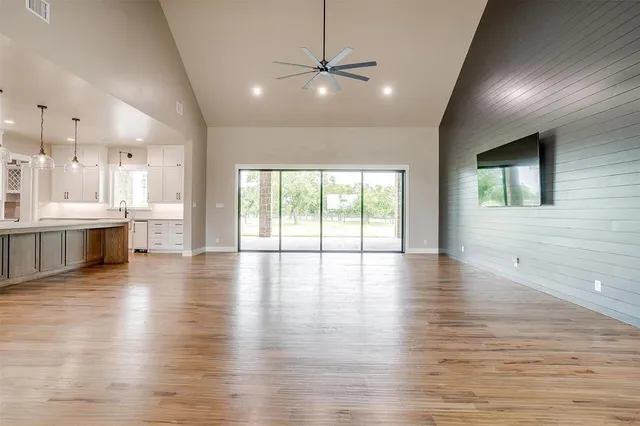 a big room with wooden floors and kitchen view