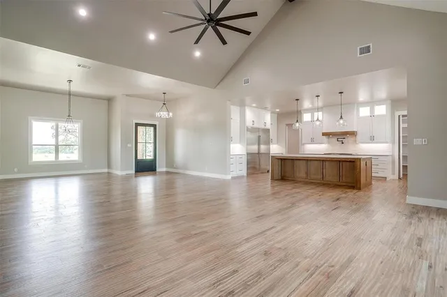 a kitchen with kitchen island a sink stove a refrigerator and a wooden floor
