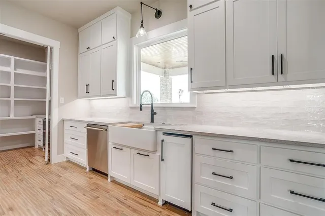 a kitchen with white cabinets and sink
