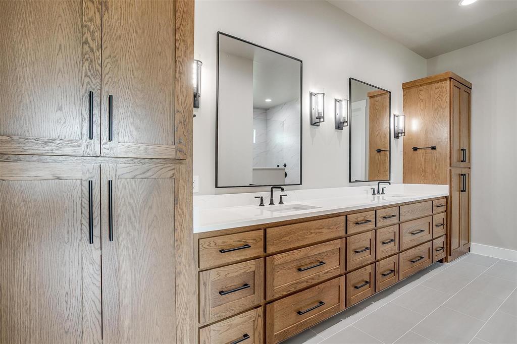 3019 Orchard Road Bowie, TX 76230 - Photo 23 of 40 a bathroom with double vanity sinks and a mirror