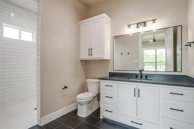 a kitchen with granite countertop white cabinets and a window