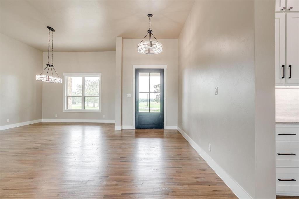 3019 Orchard Road Bowie, TX 76230 - Photo 10 of 40 a hallway with wooden floor chandelier and entryway