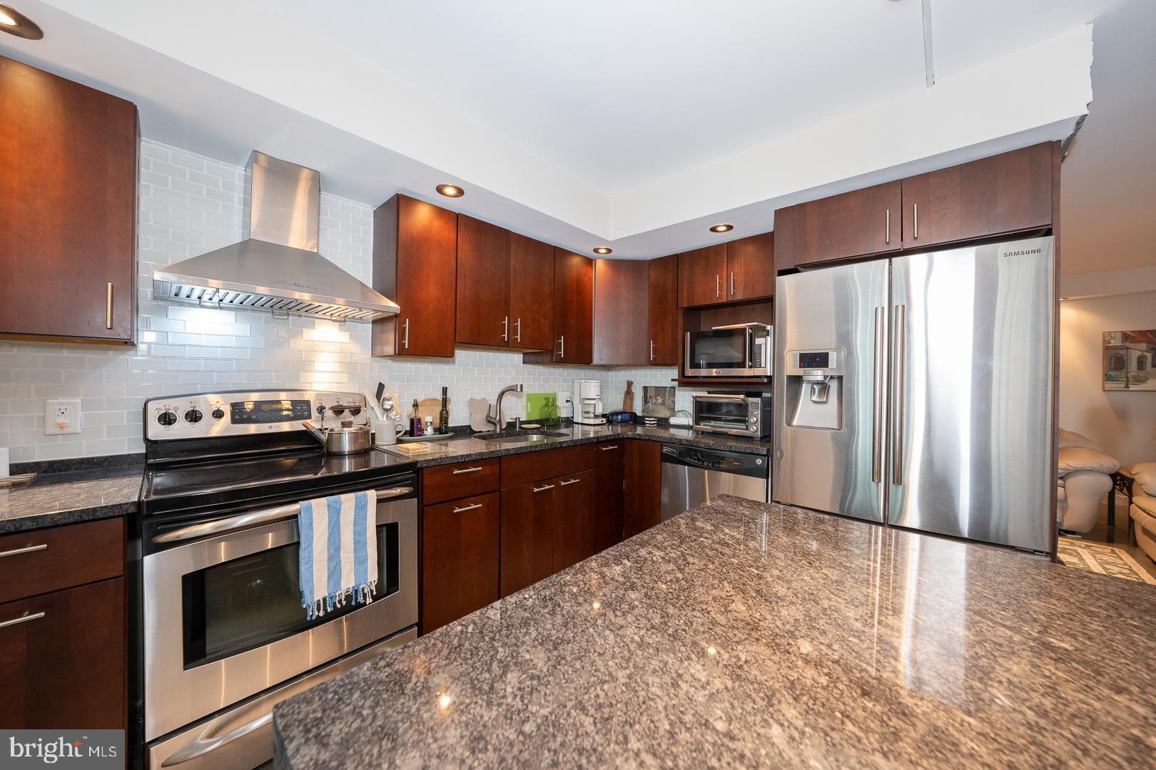 1919 Chestnut Street, Unit 1919 Philadelphia, PA 19103 - Photo 6 of 27 a kitchen with stainless steel appliances granite countertop a stove refrigerator sink and cabinets