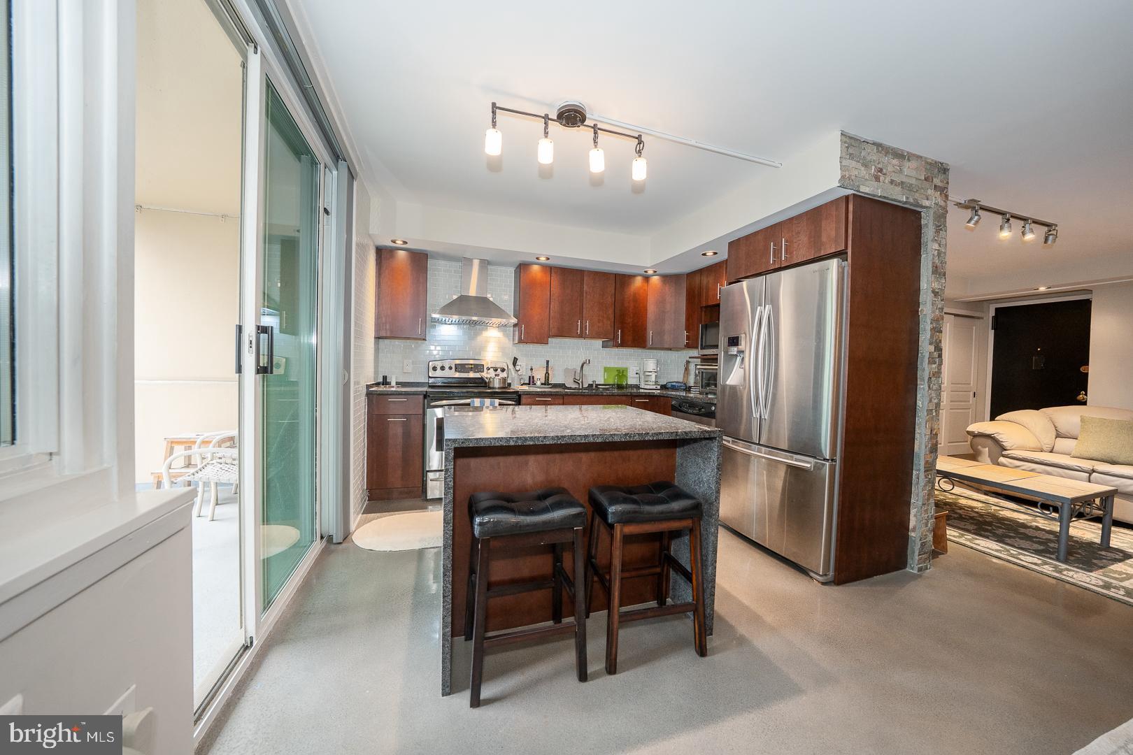 1919 Chestnut Street, Unit 1919 Philadelphia, PA 19103 - Photo 7 of 27 a kitchen with refrigerator a sink and chairs