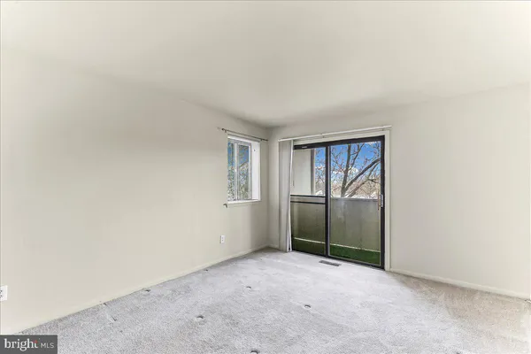 an empty room with windows and closet