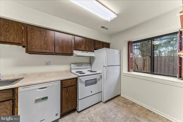 a kitchen with a sink a refrigerator and cabinets