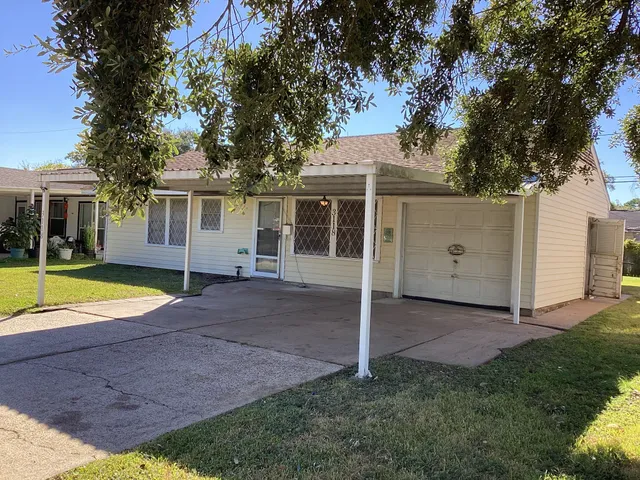 a view of a house with backyard and a tree
