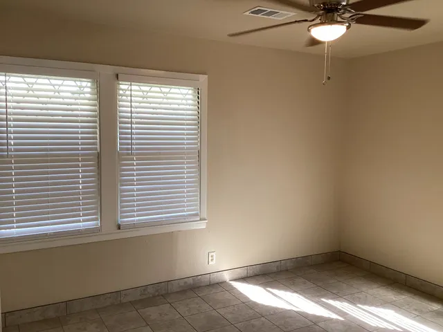 a view of a room that has a window and a fan