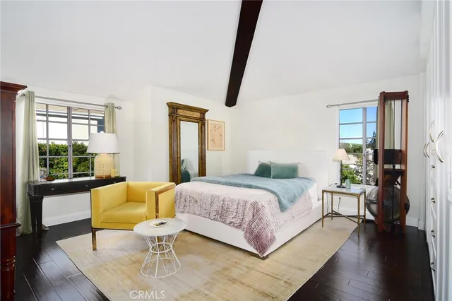 a bedroom with a bed a couch and wooden floor