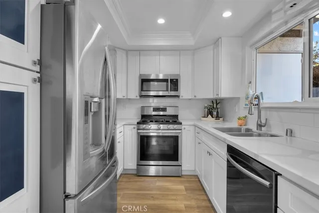 a kitchen with stainless steel appliances granite countertop a stove a sink and a refrigerator