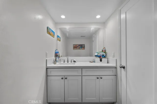 a bathroom with a sink vanity and mirror