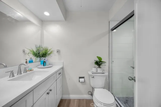 a bathroom with a granite countertop sink a toilet and a mirror