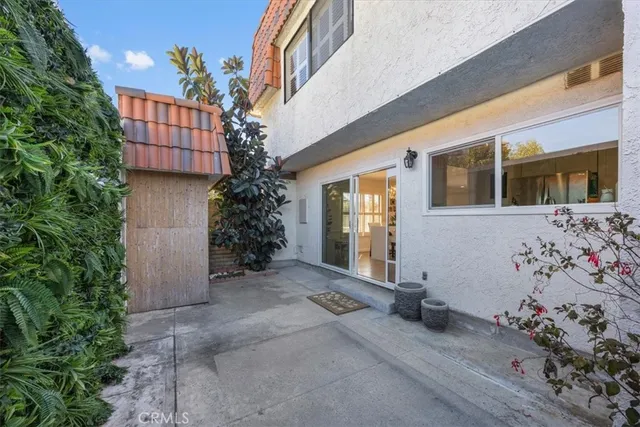 a backyard of a house with potted plants and outdoor seating