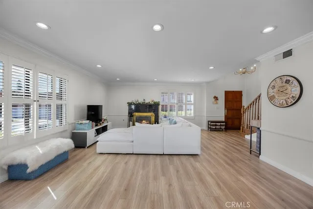 a living room with furniture a large window and wooden floor