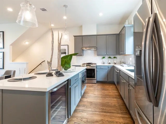a kitchen with kitchen island granite countertop a sink a counter top space stainless steel appliances and cabinets