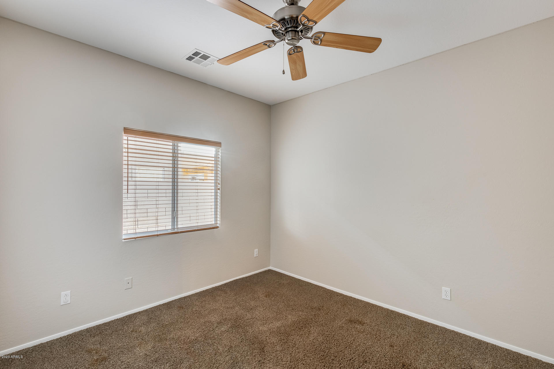 15644 West Calavar Road Surprise, AZ 85379 - Photo 4 of 34 an empty room with chandelier fan and windows
