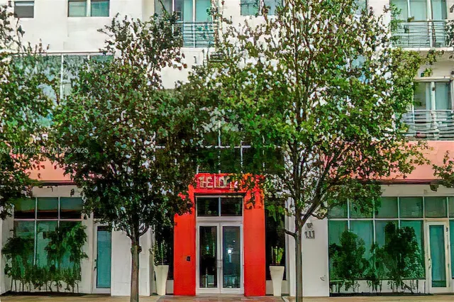 a front view of a house with a tree in front