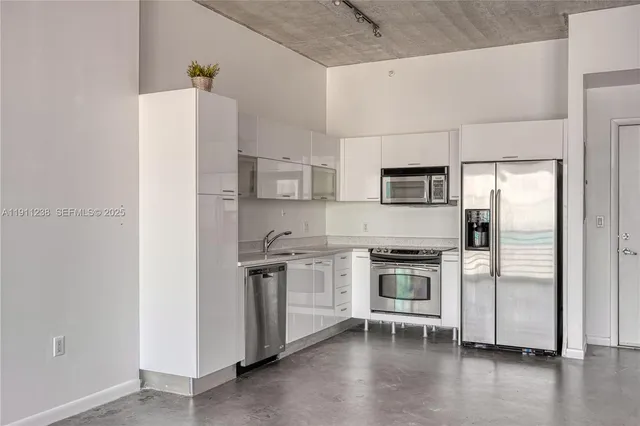 a kitchen with stainless steel appliances a refrigerator stove and wooden floor