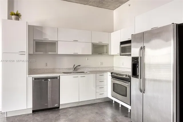 a kitchen with cabinets stainless steel appliances and a counter space