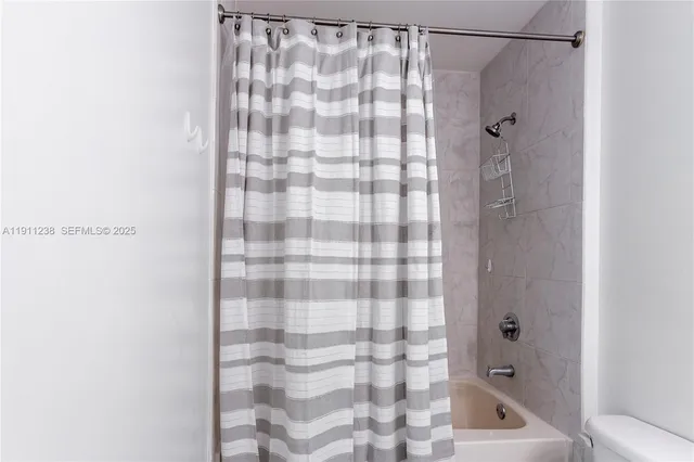 a bathroom with a shower curtain and a shower