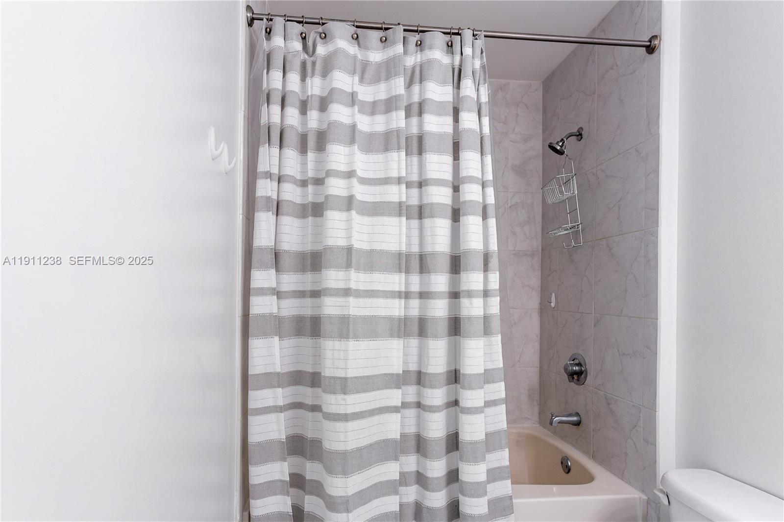 133 Northeast 2nd Avenue, Unit 2905 Miami, FL 33132 - Photo 10 of 17 a bathroom with a shower curtain and a shower
