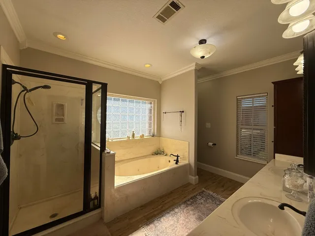 a spacious bathroom with a tub shower and sink