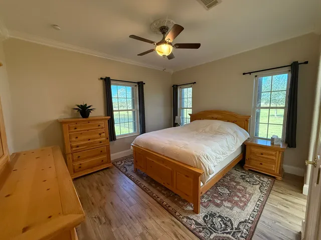 a bedroom with a bed and wooden floor