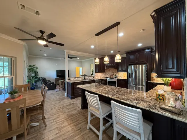 a kitchen with granite countertop a table chairs sink and wooden floor