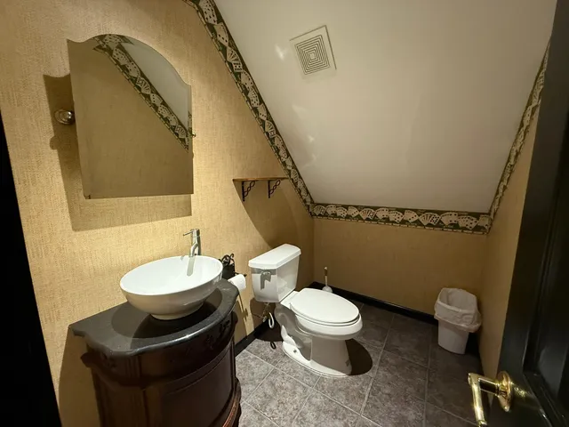 a bathroom with a toilet sink and mirror