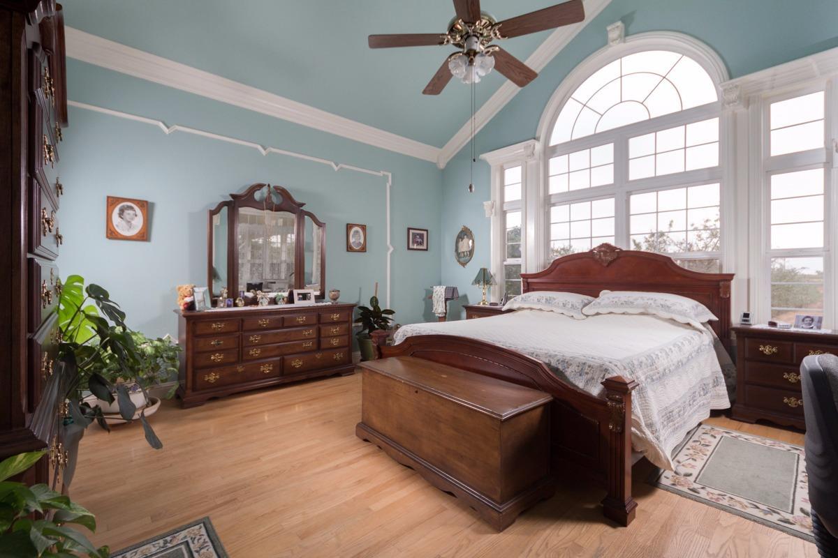 271 Wildwood Road Arbuckle, CA 95912 - Photo 5 of 7 a spacious bedroom with a bed a dresser and a large mirror
